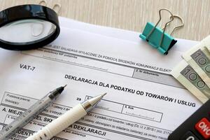 dichiarazione per imposta su merce e Servizi iva-7 modulo su contabile tavolo con penna e polacco zloty i soldi fatture foto