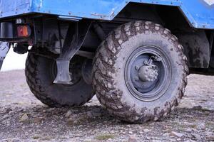 ruota avvicinamento nel un' campagna paesaggio con un' fango strada. fuori strada 4x4 suv automobile con ditry corpo dopo guidare nel fangoso strada foto