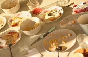 vuoto sporco piatti con cucchiai e forchette su il tavolo dopo pasto. banchetto finire concetto. non lavato piatti foto