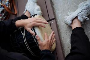 il ragazzi mani virtuosisticamente scoppio dita su il tamburellare, il africano tamburo djembe uomo giochi musica su il strada, il strumento di percussione, il percussione superficie. foto