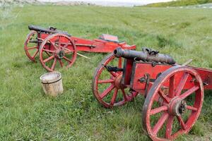 antico cannoni su ruote, utensili di il mezzo età, getto ferro cannoni di il tempo di Peter il grande, ricostruzione di storico Armi licenziare palle di cannone. foto