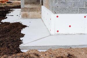 il fondazione di il Casa, il isolamento strato per il fondazione, il termico isolamento di il edificio parete, calcestruzzo impalcatura, il costruzione luogo. foto