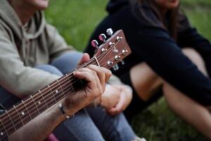 mano morsetti stringhe su chitarra, chitarra collo avvicinamento, dita in esecuzione su stringhe, musicista giocando blues, strada canzone foto