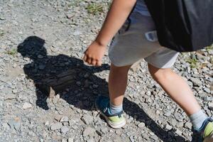 ombra a partire dal un' ragazzo su il strada, un' bambino a piedi al di fuori nel soleggiato tempo atmosferico, un astratto silhouette di un' persona, un' del bambino piede fare un passo, un' camminare nel il parco, minimalismo di ombre foto