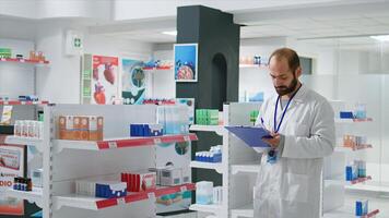 farmacia lavoratore scrittura ogni medico Prodotto su inventario, la creazione di lungo elenco con tutti farmaceutica e medicamenti nel farmacia. farmacista garantendo varietà di assistenza sanitaria forniture. telecamera 1. foto