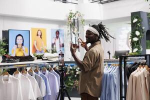 africano americano influencer promozione ultimo capi di abbigliamento collezione nel negozio. uomo blogger registrazione con abbigliamento marca pubblicità per Condividere attraverso sociale media conti foto