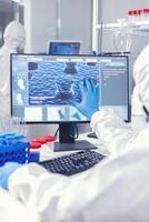 chimico uomo guardare computer schermo Lavorando su vaccino contro coronavirus nel moderno facilità. . laboratorio ingegneri conduzione sperimentare per vaccino sviluppo contro covid19 virus foto