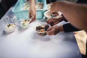 donare avanzi cibo per Affamato le persone, concetto di povertà e fame foto