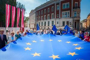 gioioso celebrazione con Unione Europea e lettone bandiere nel vecchio cittadina di riga. foto
