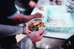 dando gratuito cibo per il povero di umano persone foto