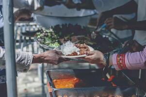 volontari offrire gratuito cibo per il povero. il concetto di cibo condivisione. foto