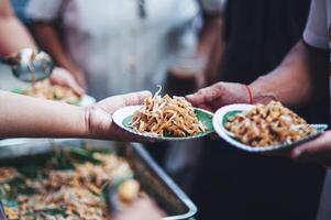 volontari siamo dando gratuito cibo per Aiuto il Affamato povero concetto di cibo condivisione foto