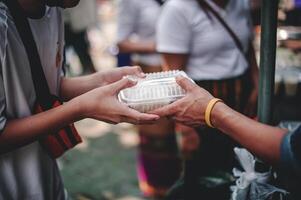 volontari offrire gratuito cibo per il povero. il concetto di cibo condivisione. foto