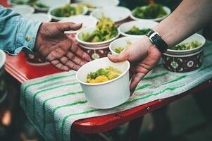 alimentazione concetto senza casa persone offrire gratuito cibo a partire dal all'aperto volontari. foto