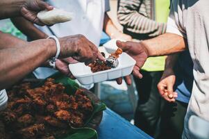 volontari siamo dando gratuito cibo per Aiuto il Affamato povero concetto di cibo condivisione foto