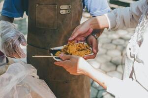 volontari offrire gratuito cibo per il povero. il concetto di cibo condivisione. foto