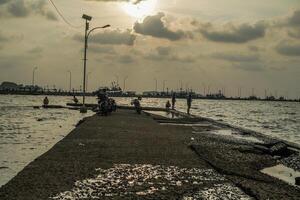 jepara, centrale Giava, aprile 7, 2024 -pescatori a il jepara molo con un' tramonto cielo come il sfondo con gratuito spazio per fotocopie. natura concetto per pubblicità. foto