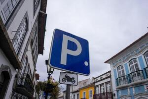 motociclo parcheggio cartello contro un' vivace urbano sfondo. Perfetto per illustrare designato parcheggio le zone nel paesaggi urbani. foto