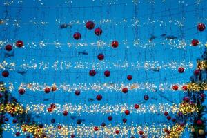 nuovo anno o Natale festivo palle e ghirlande sospeso nel righe contro il notte cielo. foto