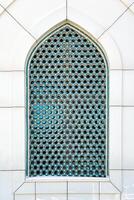 il finestra di un' musulmano moschea dietro a barre nel il modulo di un' geometrico esagonale islamico ornamento. foto