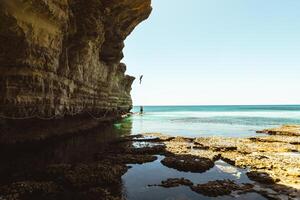 turista saltare nel acqua ayia napa baia riva con cristallo blu mediterraneo acque e tranquillo roccioso pietra mare grotte. giro turistico sentiero con corde.texture e isole geologia concetto foto