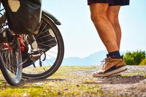 isolato in forma giovane caucasico maschio persona In piedi di bicicletta con montagne sfondo all'aperto nel Caucaso montagne. realizzazione , ispirazione, sfida e determinazione concetto foto