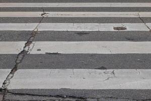 Cracked e rotto attraversamento pedonale con un' buco nel il mezzo foto