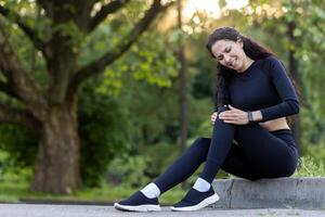 attivo donna all'aperto Tenere sua ginocchio con un' addolorato espressione, indicando un' gli sport infortunio durante allenamento. foto