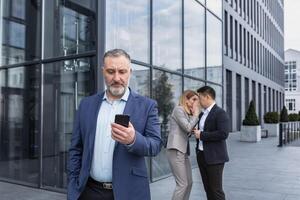 Due colleghi siamo pettegolezzi a sfondo dietro a il capo. collega di bullismo problema a opera posto nel ufficio nel il rompere al di fuori maschio collaboratori dipendenti uomo e donna sussurrando dietro a Indietro. foto