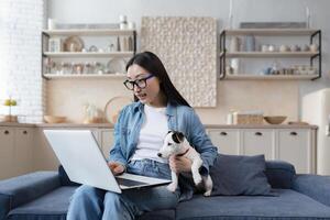 giovane bellissimo asiatico donna nel cucina adolescente usi il computer portatile alunno ragazza studi a casa. foto