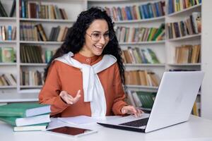 giovane ispanico donna parlando su chiamata studiando dentro Università accademico biblioteca, in linea apprendimento. foto