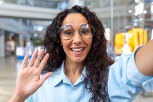 un' giovane bellissimo latino americano donna è in piedi nel un' shopping centro, parlando su un' chiamata foto