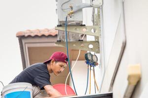 tecnico uomo installare nuovo aria condizionatore, riparatore servizio per riparazione e Manutenzione di aria balsami foto