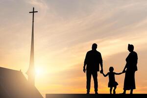 silhouette di famiglia Tenere mani godendo tramonto con sfocato il attraversare su il Chiesa foto