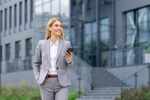 un' fiducioso femmina esecutivo è impegnato con sua Telefono prima un' aziendale ufficio, trasudante professionalità e eleganza. foto