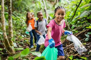 gruppo di giovane bambini avidamente don guanti e trasportare plastica borse per pulito su il ambiente foto