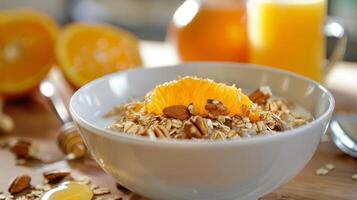 un' caldo ciotola di fiocchi d'avena sormontato con tostato noccioline e un' pioggerella di miele servito con un' lato di appena spremuto arancia succo foto