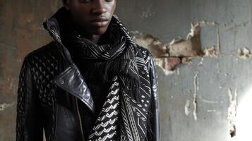 Questo tagliente Guarda combina un' pelle giacca con 3d stampato geometrico dettagli e un' tradizionale tessuto a mano sciarpa foto