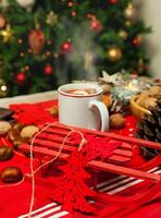 tazza di caldo tè su con dietro a Natale albero. foto