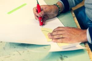 scarpa progettista Lavorando con carta Modelli per pelle taglio. foto