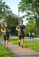 Due amici in esecuzione con verde maglietta nel parco foto