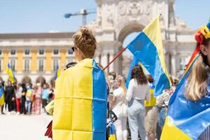 Portogallo, Lisbona aprile 2022 il dimostrazione su commercio piazza nel supporto di Ucraina e contro il russo aggressione. manifestanti contro di russia guerra molti persone con ucraino bandiere. foto