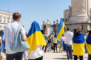 Portogallo, Lisbona aprile 2022 il dimostrazione su commercio piazza nel supporto di Ucraina e contro il russo aggressione. manifestanti contro di russia guerra molti persone con ucraino bandiere. foto