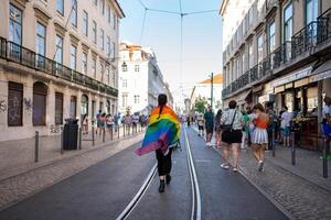 gay persona con arcobaleno bandiera a piedi su strade di Lisbona foto