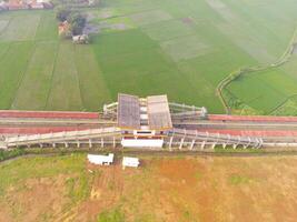 nebbioso Visualizza di il ferrovia stazione. aereo Visualizza di treno traccia e stazione nel rancaekek, bandung - Indonesia. naturale condizioni. sopra. pubblico trasporto. tiro nel fuco volante 100 metri foto