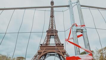 selettivo messa a fuoco di rosso e bianca attenzione nastro su un' metallo barriera con il iconico eiffel Torre nel il sfondo, Parigi, Francia, aprile 14, 2024 foto