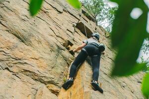 giovane atletico donna nel attrezzatura fare roccia arrampicata all'aperto. formazione la zona per all'aperto attività. estremo sport. foto