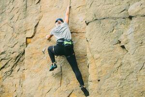 giovane atletico donna nel attrezzatura fare roccia arrampicata all'aperto. formazione la zona per all'aperto attività. estremo sport. foto