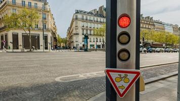 rosso traffico leggero e bicicletta cartello a un' parigino attraversamento pedonale con haussmanniano edifici nel il sfondo, urbano viaggio concetto, Europa foto