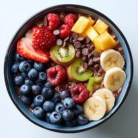 cioccolato fiocchi d'avena con un' varietà di frutta nel blu ciotola isolato su bianca sfondo. cioccolato fiocchi d'avena con fragole, mirtilli e banane superiore Visualizza foto